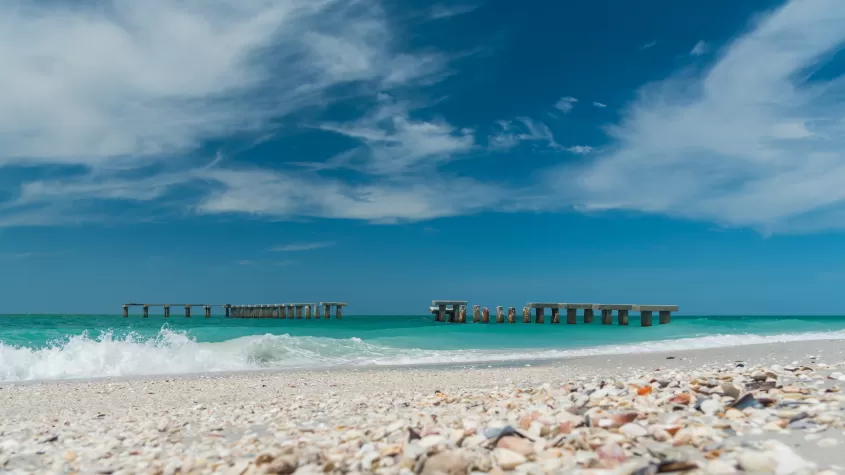 boca grande beach with shells in the foreground and pierhenge in the background