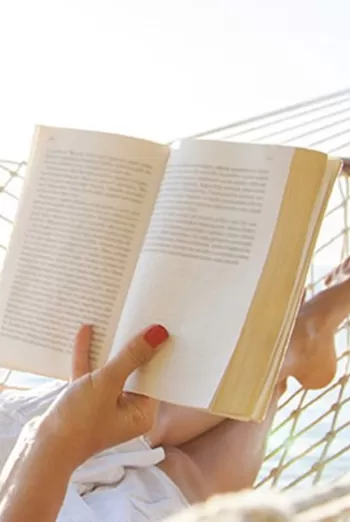 woman reading book in hammock