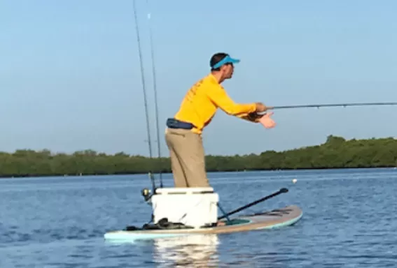 A person fly-fishes on a paddle board in Matlacha